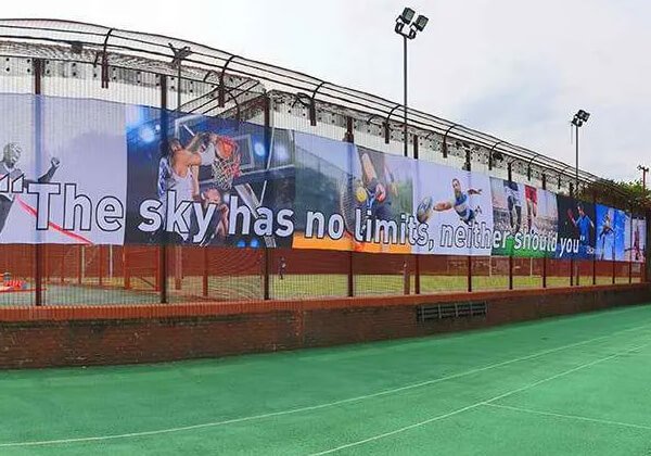Fabric banner on display around the edge of an astro turf football pitch