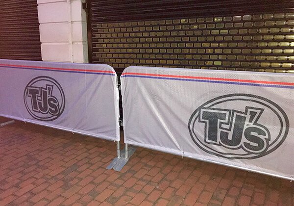 Two elite crowd barrier covers on display outside TJ's bar