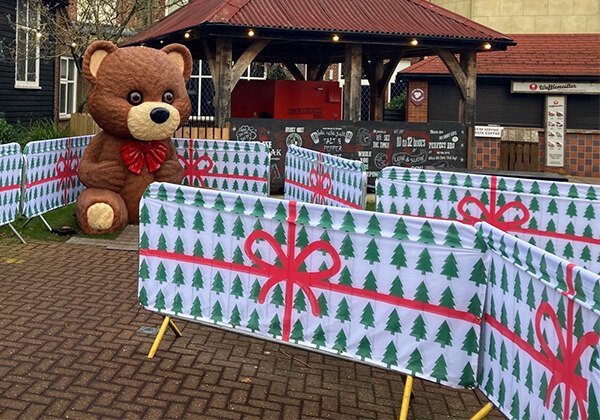 Daytime image of festive crowd barrier covers printed and installed at Chessington World of Adventures