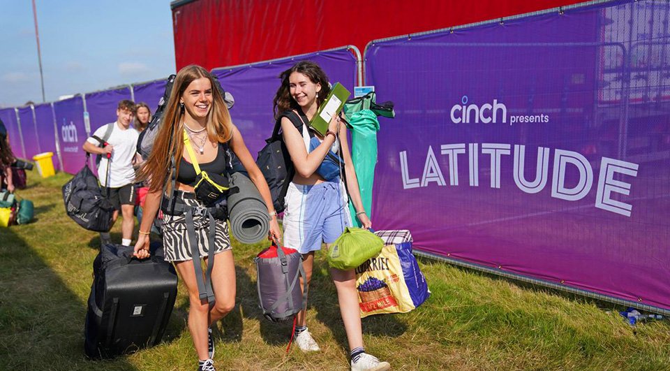 Two festival goers next to Heras Fence Covers at Latitude festival