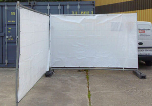 White fence tarpaulin attached to Heras fence panels