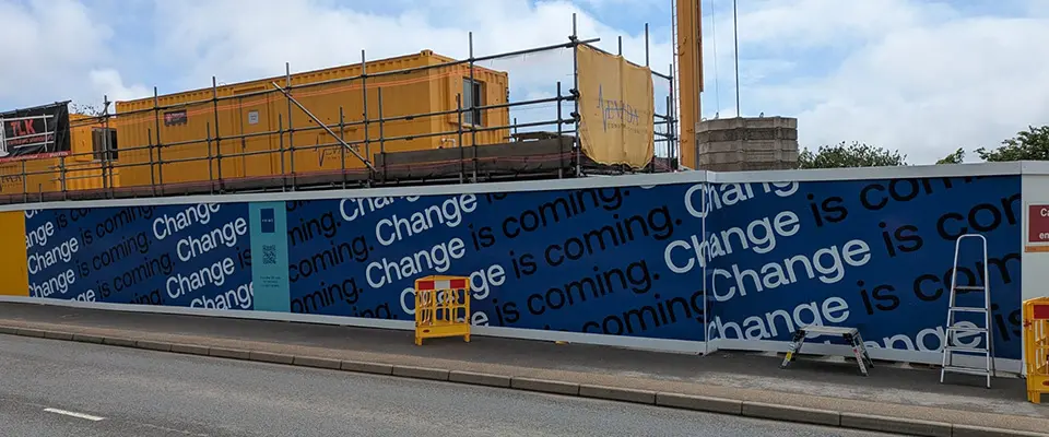 Full Service Hoarding Signage for Nevada Construction 1 Installed blue and white 'Change is coming' branded hoarding signage featuring integrated QR codes on-site in Truro.