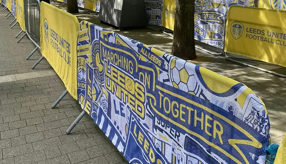 Leeds United FA Cup Semi-Final Branding at Wembley Stadium 3 A long row of premium barrier covers in Leeds United's signature yellow and blue, highlighting the matchday slogan "Marching On Together".