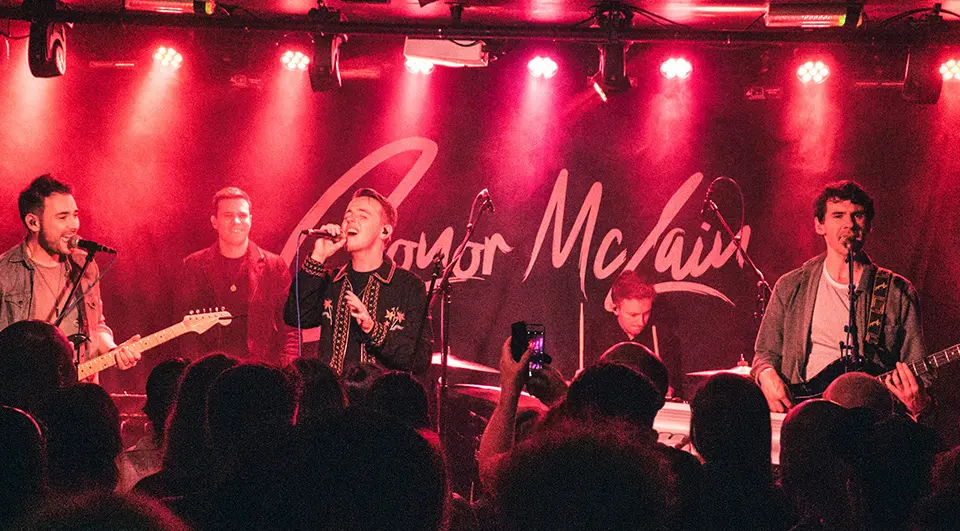 7 Band Backdrop Ideas that actually work on stage 20 Conor McLain backdrop with signature-style script name behind the band at a live gig