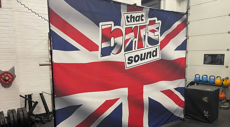 7 Band Backdrop Ideas that actually work on stage 16 That Brit Sound backdrop with edge-to-edge Union Jack print and logo, on a freestanding frame